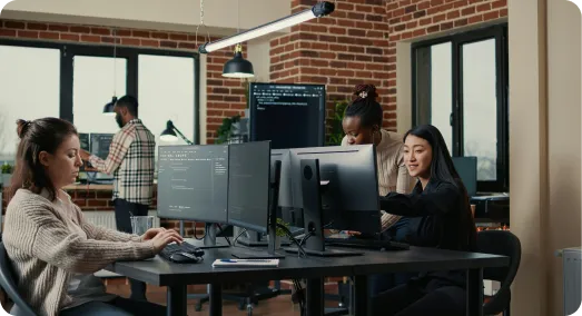 A diverse group of people working in a room with computers