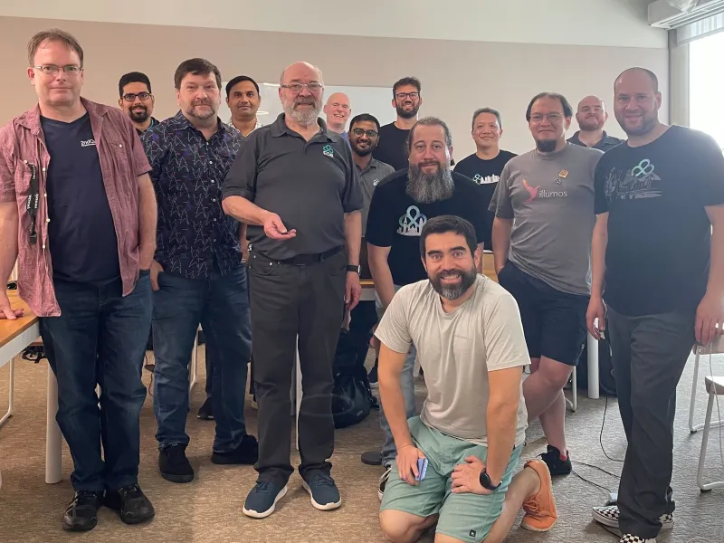 A group photo of the Developer U trainers and trainees, some wearing EDB shirts, or references to open source software.