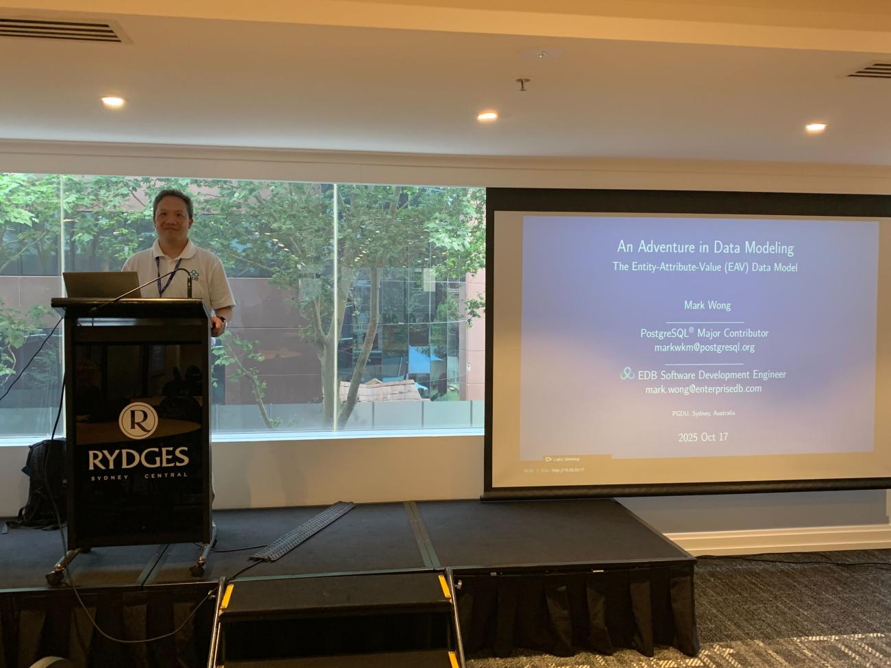 Mark Wong at Postgres Down Under, presenting in front of a screen