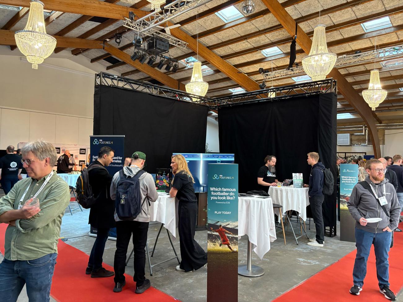 The EDB booth at Cloud Native Denmark, 3 standing tables, colleagues talking to attendees