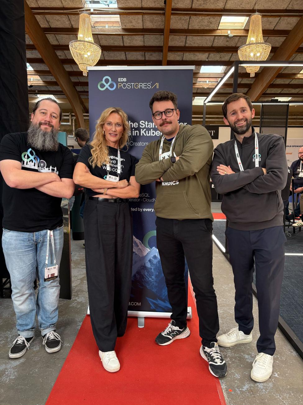 EDB team members group photo in front of a rollup banner and on a strip of red carpet