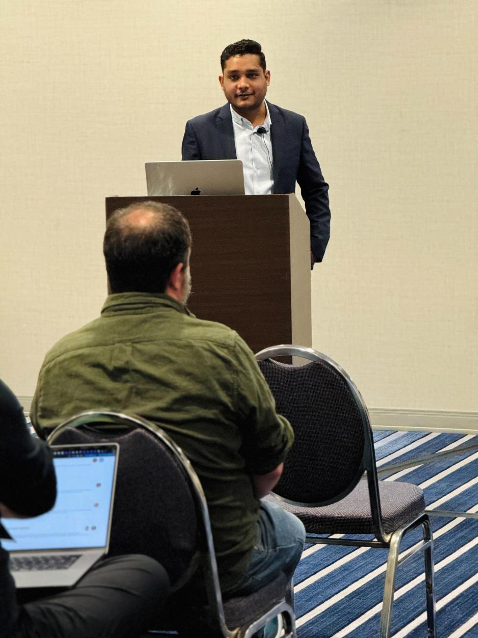 Yogesh Jain behind the speakers stand at Postgres Conference San Jose