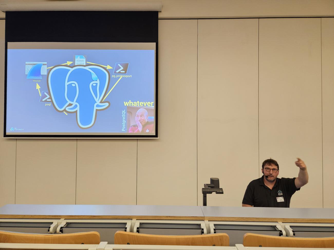 Xavier Fischer presenting his PGConf BE session, a big Slonik on the slide.