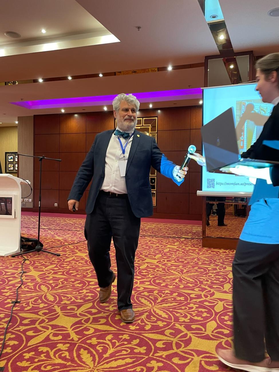 Bruce handing the microphone back to PGDay Armenia organizer Emma Saroyan