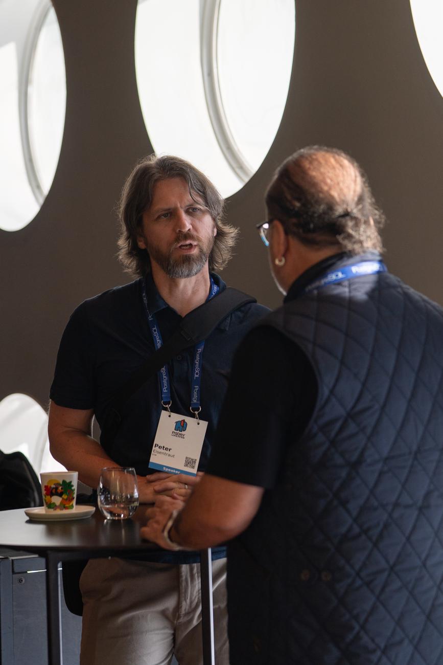 Peter Eisentraut and Devrim Gunduz talking at PgDay Lowlands