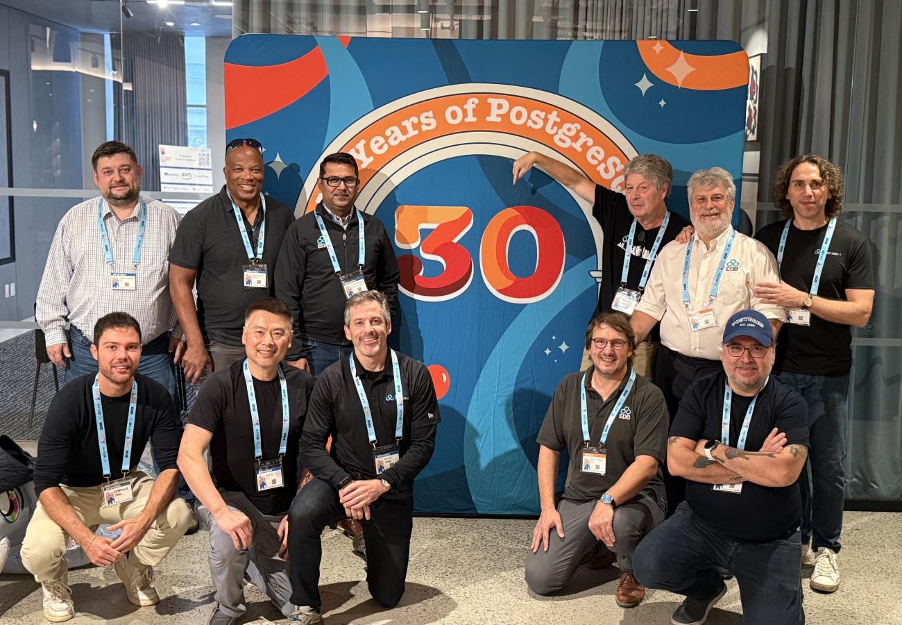 Group photo at the Postgres 30 years anniversary banner